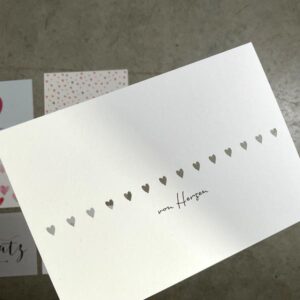 postkarte mit ausgeschnittenen Herzchen