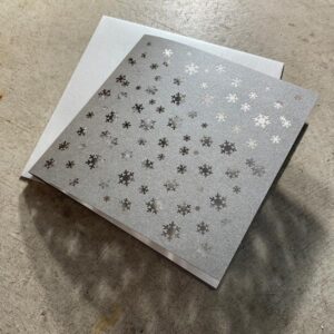 grusskarte mit ausgeschnittenen schneeflocken