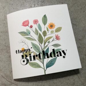 rippenpapier mit bedruckten gezeichnetetn blumen und ausgeschnittenem happy birthday